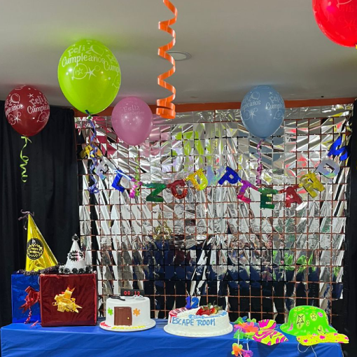 Mesa de cumpleaños decorada en sala de escape con tortas y pistas en Bogotá